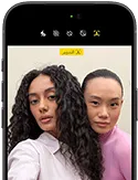 جهاز iPhone&nbsp;18&nbsp;Pro، بلون أسود، الجهة الخارجية الأمامية، عارضتان تتخذان وضعية التصوير أمام الكاميرا، استعراضاً لكاميرا Center&nbsp;Stage الأمامية